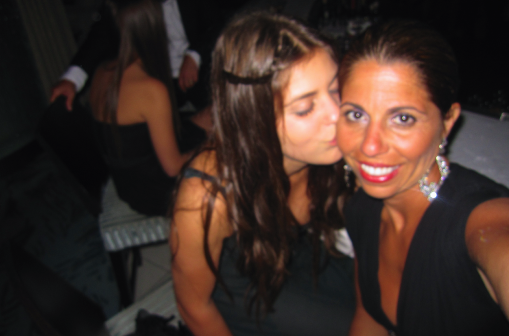 Tammy taking a selfie while receiving a kiss on the cheek from her daughter.