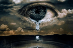 An eye in a cloudy sky with tears falling from it into water below.